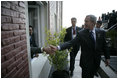 President George W. Bush reaches out for the hand of a well-wisher after participating in the 2005 class photo during opening ceremonies Friday, Nov. 4, 2005, of the Summit of the Americas in Mar del Plata, Argentina.