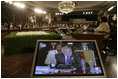 President George W. Bush and Secretary of State Condoleezza Rice are shown on a video monitor as the President speaks Friday, Nov. 4, 2005, during the opening session of the 2005 Summit of the Americas in Mar del Plata, Argentina.