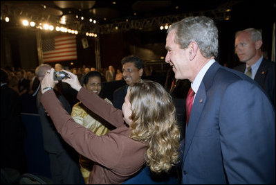 President George W. Bush poses for a photo with an audience member after delivering remarks in Brasilia, Brazil, Sunday, Nov. 6, 2005. 