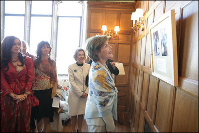 Mrs. Laura Bush looks over a photographic exhibit during a luncheon in Mar del Plata Saturday, Nov. 5, 2005, hosted by Argentine First Lady Mrs. Cristina Fernandez de Kirchner, far left. 