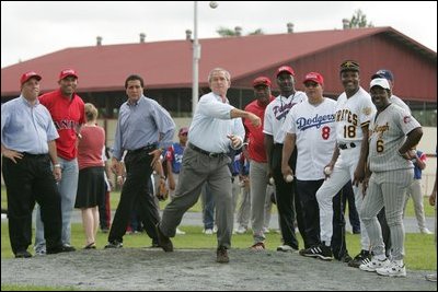 Under the watchful eyes of New York Yankee's Mariano Rivera, second from left, and Panama President Martin Torrijos, third from left, President George W. Bush releases a pitch Monday, Nov. 7, 2005, during a visit with Panamanian youth at Ciudad Del Saber in Panama City, Panama. 