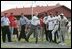 Under the watchful eyes of New York Yankee's Mariano Rivera, second from left, and Panama President Martin Torrijos, third from left, President George W. Bush releases a pitch Monday, Nov. 7, 2005, during a visit with Panamanian youth at Ciudad Del Saber in Panama City, Panama. 