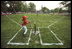 A Rockies player swings during a tee-ball game on the South Lawn May 6, 2001. The Rockies are part of Capitol City Little League in Washington, D.C.