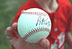 A Rockies player shows off his signed baseball from the afternoon during a tee-ball game on the South Lawn May 6, 2001.