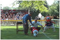 President George W. Bush and Commissioner Cal Ripken signal a "safe" for a player who took an unplanned slide as he ran toward them for his courtesy baseball and photo after the game Sunday, May 5, 2002.