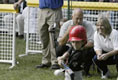 A little slugger from Kalamazoo, Mich., takes his hit under the expert gaze of Honorary Commissioner and Baltimore Orioles great Cal Ripken and Olympic Gold Medalist and Honorary Third Base Coach Dot Richardson during the last game of the White House South Lawn Tee Ball season Sunday, Sept. 7, 2003.