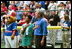 President Bush starts off the first game of the 2004 White House Tee Ball season with the pledge of allegiance June 13, 2004. Standing with the President are members of Girl Scout Troop.