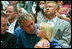 During the game, President Bush spends a few moments with a little league fan during the first game of the 2004 White House Tee Ball season June 13, 2004.