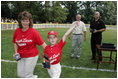 A player from the Challenger Phillies from Middletown, Delaware celebrates receiving a baseball from President George W. Bush and Cal Ripken Jr. at Tee Ball on the South Lawn at the White House on Sunday July 11, 2004.