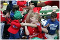 A young ballplayer from the West University Little League Challengers from Houston, Texas,  cheers with her team Sunday, July 24, 2005, at a Tee Ball game on the South Lawn of the White House.