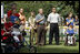 President George W. Bush listens to the National Anthem before a Tee Ball game on the South Lawn of the White House between the District 12 Little League Challengers from Williamsport, PA and the West University Little League Challengers from Houston, Texas on Sunday July 24, 2005.