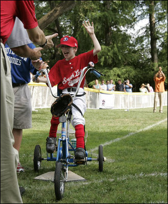 A player from the West University Little League Challengers from Houston, Texas, is welcomed as he crosses homeplate to score a run, Sunday, July 24, 2005, during a Tee Ball game on the South Lawn of the White House.