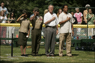 President George W. Bush is joined by Barry Larkin, White House Tee Ball Commissioner of the Game and Young Marines as they stand for the National Anthem Sunday, June 26, 2005, during "Tee Ball on the South Lawn."