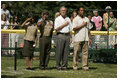 President George W. Bush is joined by Barry Larkin, White House Tee Ball Commissioner of the Game and Young Marines as they stand for the National Anthem Sunday, June 26, 2005, during "Tee Ball on the South Lawn."