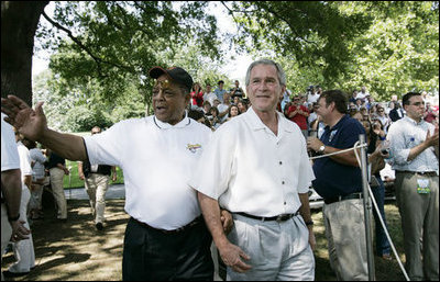 Baseball legend and hall of famer Willie Mays walks with President George W. Bush as he acknowledges a standing ovation from the crowd Sunday, July 30, 2006, upon their arrival for the Tee Ball on the South Lawn game between the Thurmont Little League Civitan Club of Frederick Challengers of Thurmont, Md., and the Shady Spring Little League Challenger Braves of Shady Spring, W. Va. Mays was the honorary Tee Ball Commissioner for the game. 