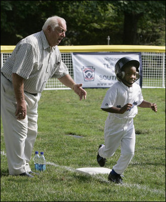 Hall of Fame baseball manager Tommy Lasorda urges on a player from the Wrigley Little League Dodgers of Los Angeles, as he runs for home against the Inner City Little League of Brooklyn, N.Y., Sunday, July 15, 2007, during the White House Tee Ball Game celebrating the legacy of Jackie Robinson on the South Lawn of the White House. Brooklyn and Los Angeles represent the two home cities of Robinson’s team.