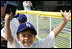 An excited member of the Wrigley Little League Dodgers of Los Angeles shows off his Presidential autographed baseball following their game against the Inner City Little League of Brooklyn, N.Y., Sunday, July 15, 2007, at the White House Tee Ball Game celebrating the legacy of Jackie Robinson on the South Lawn of the White House. Brooklyn and Los Angeles represent the two home cities of Robinson’s team.