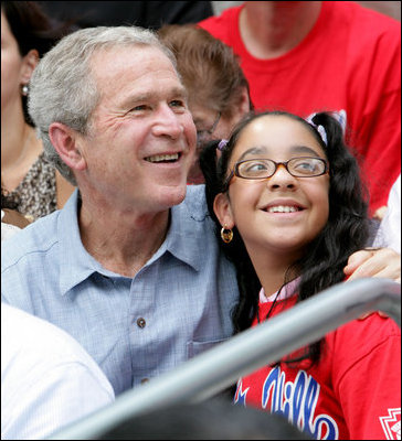 President George W. Bush poses for a photo with a fan in the stands Monday, June 30, 2008, during the opening game of the 2008 Tee Ball season between the Cramer Hill Little League Red Sox of Camden, N.J., and the Jose M. Rodriguez Little League Angels of Manatí, Puerto Rico, on the South Lawn of the White House.