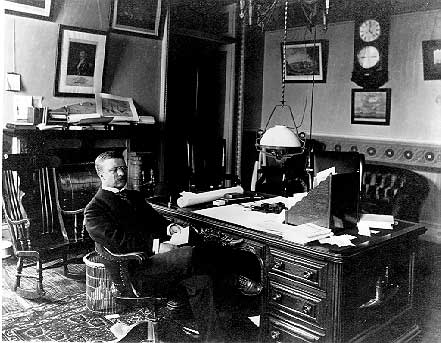 Black and white photo of then Vice President Theodore Roosevelt sitting at his desk in the Vice President's Office.