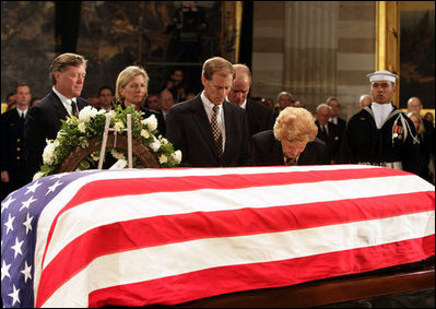 Former first lady Betty Ford kneels at the casket of her husband, former President Gerald R. Ford, in the U.S. Capitol rotunda during the State Funeral ceremony, Saturday, December 30, 2006. Accompanying Mrs. Ford are her children, from left, John G. Ford, Susan Ford Bales, Michael Ford and Steven Ford.