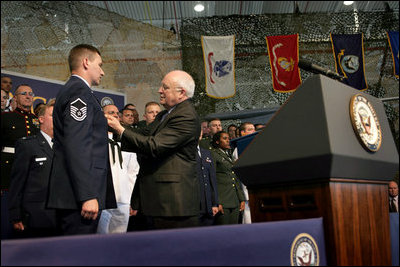 Vice President Dick Cheney pins the Purple Heart Medal onto Master Sergeant Henry G. Christle, Jr., Monday, July 10, 2006, during a rally for the Michigan National Guard and Joint Services at Selfridge Air National Guard Base in Harrison Township, Mich. Master Sergeant Christle was wounded in action on March 23, 2004 while serving as a Special Operations Weather Team Forecaster and Observer assigned to the Combined Joint Special Operations Task Force 180, Afghanistan.