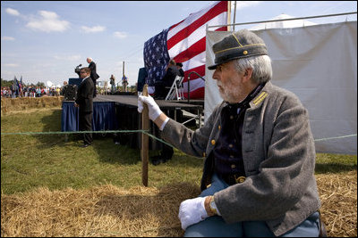 Vice President Dick Cheney delivers remarks during the commemoration of the 145th anniversary of the Battle of Chickamauga in McLemore's Cove, Georgia, as a Confederate re-enactment participant looks on.