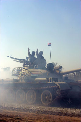 Vice President Dick Cheney visits the 9th Mechanized Infantry Division Headquarters at Taji Air Base to greet Iraqi troops and view tanks and armored vehicles they have refurbished into working fighting vehicles, Sunday Dec. 18, 2005.