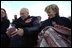 Vice President Dick Cheney signs a football for a Natrona County High School student while watching the school's homecoming game with his high school sweetheart, Lynne Cheney, in Casper, Wyo., Sept. 20, 2002. 