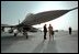 Standing under a compact, 16-foot tall F-16 fighter jet, Vice President Dick Cheney talks with an Air Force pilot on his tour of the Al-Udeid Airbase in Qatar, March 17, 2002.