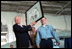 Sharing the stage with artist Chad DuLac, Vice President Dick Cheney displays a drawing of himself while aboard the USS Stennis Aircraft Carrier March 15, 2002.