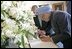 India's Prime Minister Dr. Manmohan Singh is accompanied by U.S. Department of State Chief of Protocol Ambassador Donald Ensenat, Monday, July 18, 2005, as Singh signs the guest book upon his arrival to the White House. 