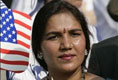 A guest attending the official arrival of India's Prime Minister Dr. Manmohan Singh, holds an American and India flag, Monday, July 18, 2005, on the South Lawn of the White House. 