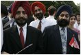 Guests wait for the official arrival ceremony of India's Prime Minister Dr. Manmohan Singh, holds an American and India flag, Monday, July 18, 2005, on the South Lawn of the White House. 