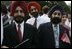 Guests wait for the official arrival ceremony of India's Prime Minister Dr. Manmohan Singh, holds an American and India flag, Monday, July 18, 2005, on the South Lawn of the White House. 