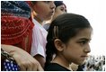 A young girl waits for the official arrival of India's Prime Minister Dr. Manmohan Singh, holds an American and India flag, Monday, July 18, 2005, on the South Lawn of the White House. 