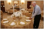 Last minute checks and adjustments are made on the table arrangements in the State Dining Room, Wednesday, Nov. 2, 2005, in preparations for the official dinner for the Prince of Wales and Duchess of Cornwall at the White House.