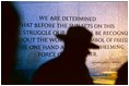 National Park Service Ranger Mike Balis leads a tour near the north end of the memorial plaza. The quote on the Northern Wall by General George C. Marshall states: .We are determined that before the sun sets on this terrible struggle our flag will be recognized throughout the world as a symbol of freedom on the one hand and of overwhelming force on the other.. 