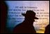 National Park Service Ranger Mike Balis leads a tour near the north end of the memorial plaza. The quote on the Northern Wall by General George C. Marshall states: .We are determined that before the sun sets on this terrible struggle our flag will be recognized throughout the world as a symbol of freedom on the one hand and of overwhelming force on the other.. 