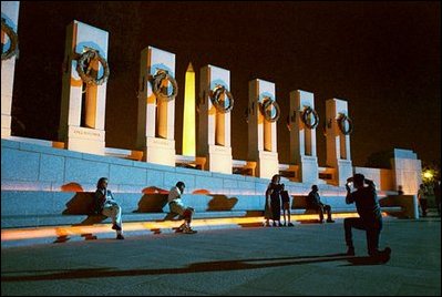 As night falls over the memorial, visitors cool off on the granite benches of the National World War II Memorial the week before its official dedication during Memorial Day Weekend.