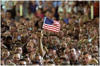 A veteran waves an American flag during President Bush's address to members of the Florida National Guard, veterans and retired members of the military at MacDill Air Force Base in Tampa, Fla., March 26, 2003. "I want to thank you all for your service, for setting such a clear example for future generations of those who wear our uniform. I think you'll agree that our military is not letting you down when it comes to upholding the great tradition of peace through strength.. said the President"