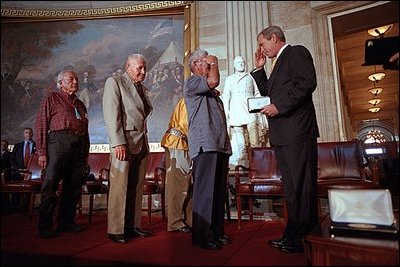 President George W. Bush salutes Navajo Code Talkers during a ceremony at the U.S. Capitol July 26, 2001. .In war, using their native language, they relayed secret messages that turned the course of battle. At home, they carried for decades the secret of their heroism,. said the President who presented medals to 21 Native Americans who served during World War II.